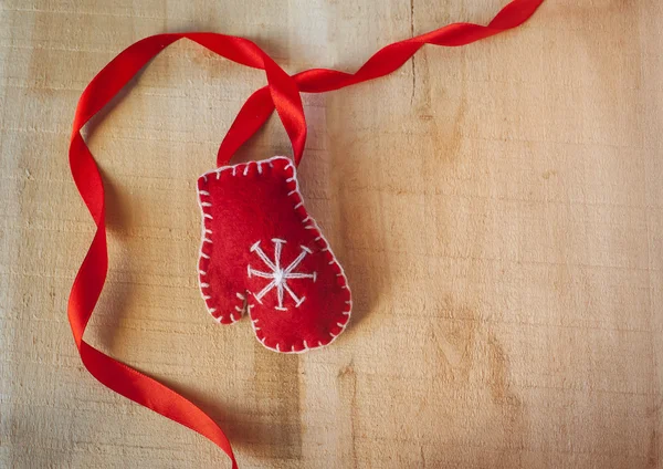 Cornice natalizia con guanti rossi Babbo Natale su uno sfondo di legno — Foto Stock
