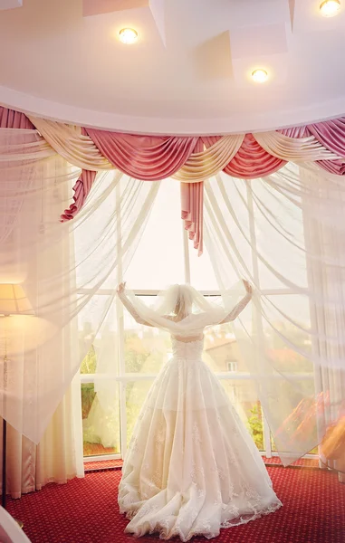 Portrait of the beautiful bride against a window indoors — Stock Photo, Image