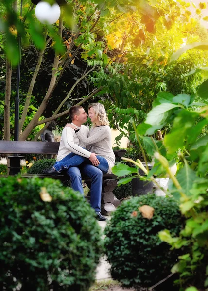 Pareja amorosa en un banco en el parque de otoño —  Fotos de Stock