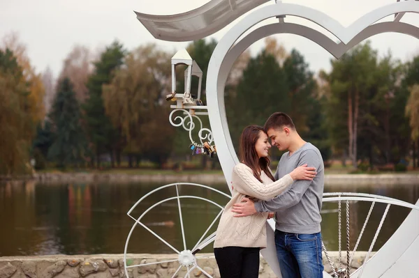 Affectionate young couple standing together in the park girl smi — Stock Photo, Image
