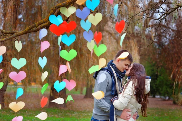 Pareja besándose en el parque, decoración fondo de corazones de p — Foto de Stock