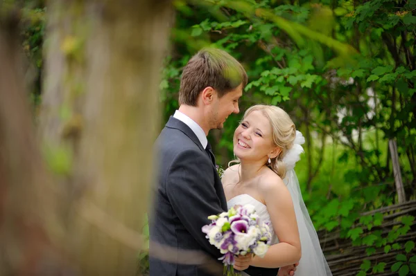 Bruid en bruidegom wandelen in het park gelukkig — Stockfoto