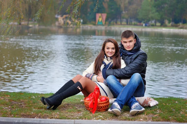 Menino e menina no parque em um fundo de água com maçãs — Fotografia de Stock