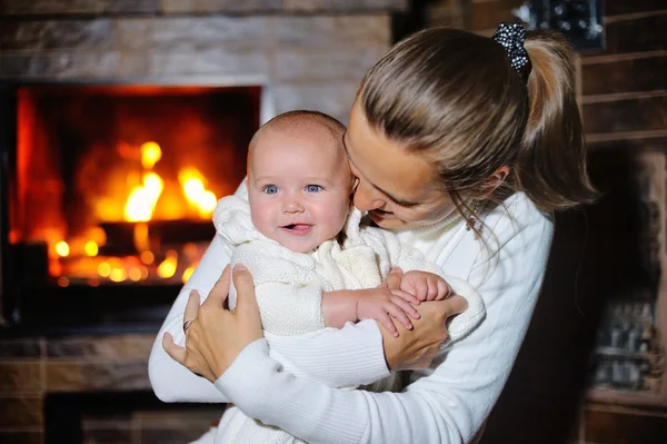 Mutter küsst Tochter am brennenden Kamin — Stockfoto