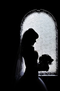 Gelin onu düğün buket ile pencere dışında silüeti 