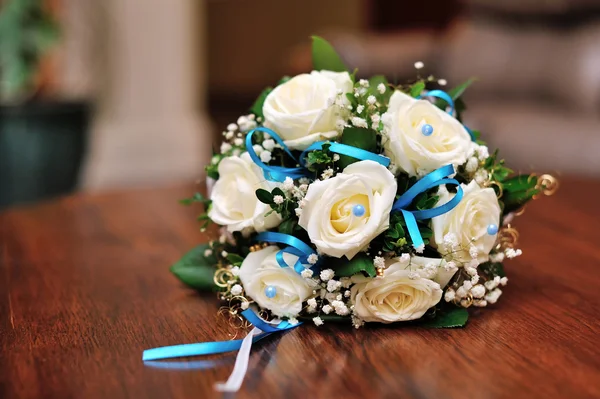 Ramo de boda de rosas crema y hojas verdes en banco de madera —  Fotos de Stock