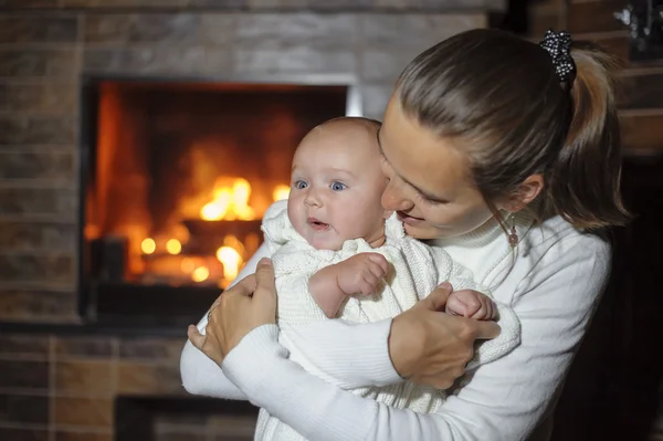 Mother with her daughter at the fireplace — Stock Photo, Image