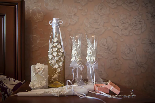 Bröllop-glasögon och en flaska inredda med vita blommor — Stockfoto