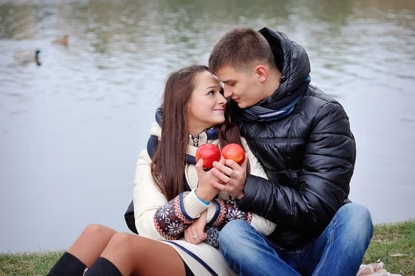 Couple on a background of water in autumn with apples — Stock Photo, Image