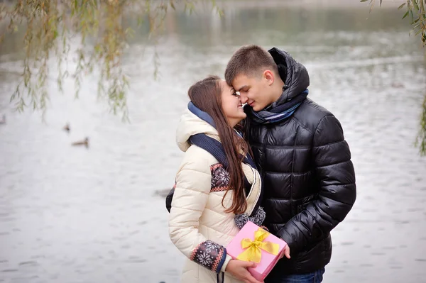 Imagen de chico cariñoso besando a su novia mientras le da — Foto de Stock