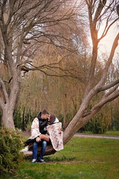 Man och kvinna gå i höst park täckt med en filt — Stockfoto