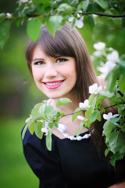 Bella giovane donna bruna sul prato con fiori bianchi — Foto Stock