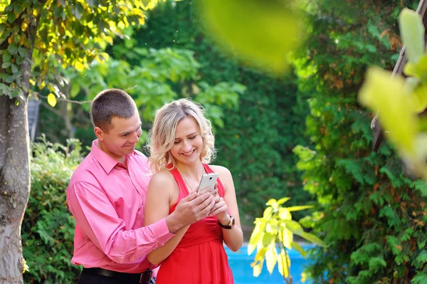 Young couple to see the smartphone in the park — Stock Photo, Image