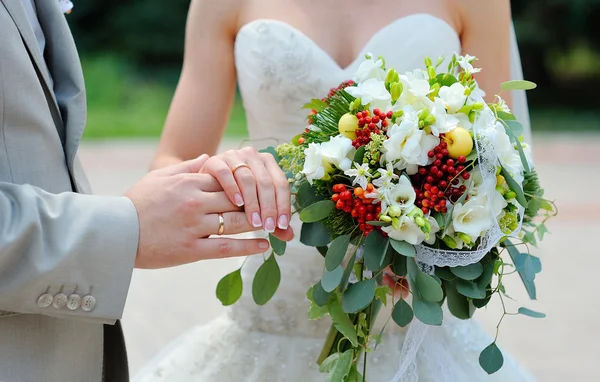 De trouwringen van bruid en bruidegom op de achtergrond van het boeket — Stockfoto