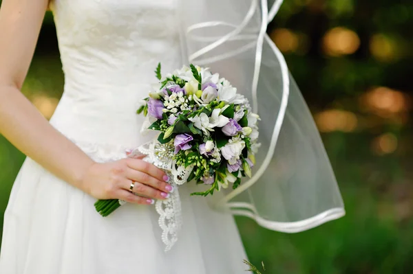 美しい結婚式の花嫁の手に紫の花束 — ストック写真