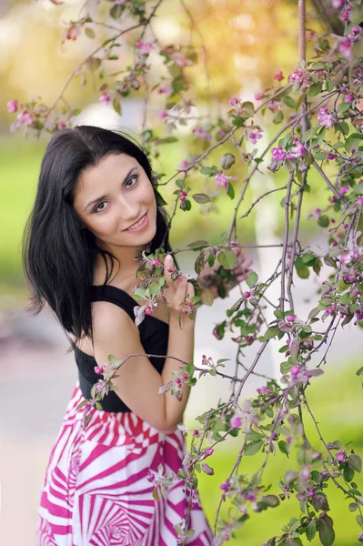 Mooie jonge vrouw in de zomertuin — Stockfoto