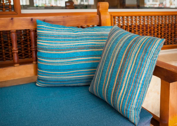 Blue cushions on the wooden sofa in the park — Stock Photo, Image