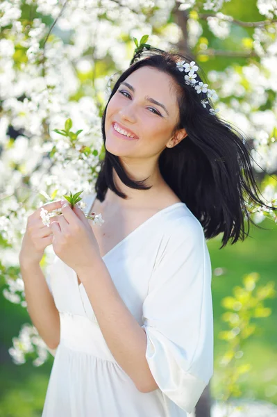 Mulher sorridente no jardim florescente de primavera — Fotografia de Stock