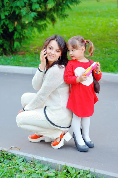 Mãe e filha conversam ao telefone no parque — Fotografia de Stock