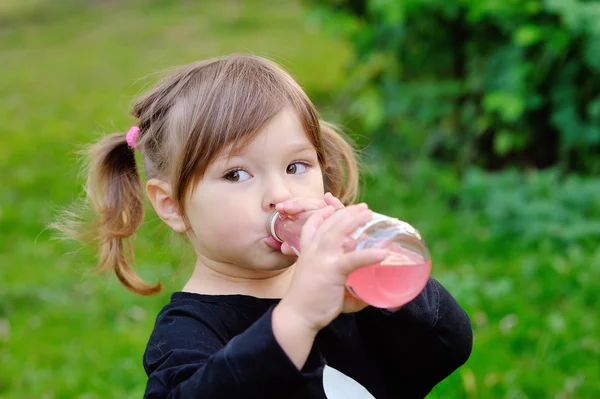 Bambina che beve da una bottiglia di bevanda — Foto Stock