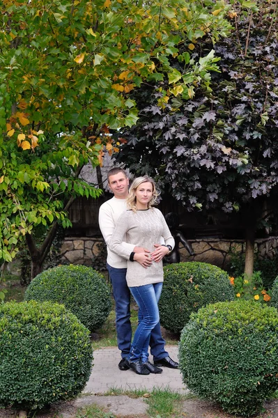 Liefdevolle man knuffelen een vrouw in het park — Stockfoto