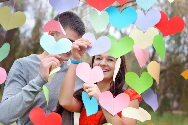 Pareja enamorada el día de San Valentín en el parque con corazones — Foto de Stock