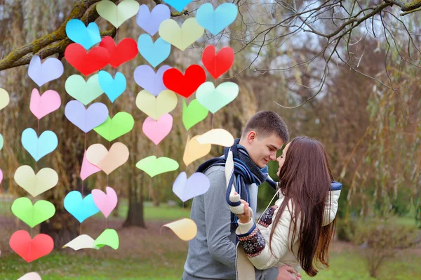 Pareja enamorada el día de San Valentín en el parque con corazones — Foto de Stock