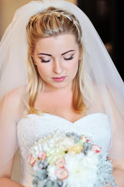 Retrato de una hermosa novia rubia con un ramo de flores — Foto de Stock