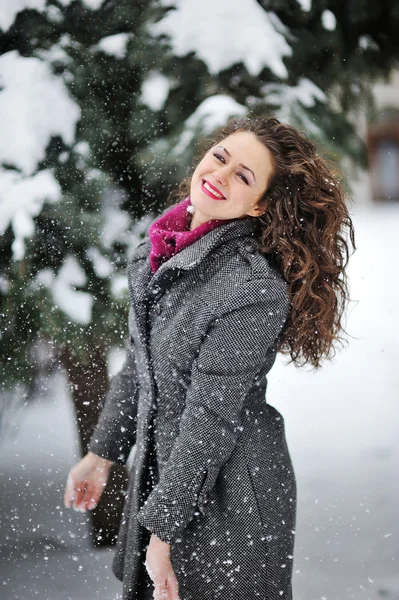美しい女性は、冬の雪を楽しんでいます — ストック写真