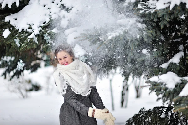 Schöne Frau im Winter Strickhandschuhe wirft Schnee — Stockfoto