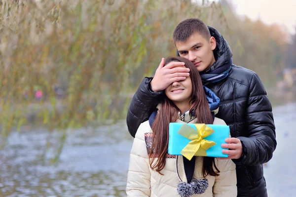 Casal apaixonado homem dá um presente uma mulher — Fotografia de Stock