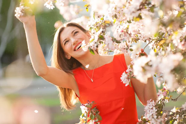 Vackra leende kvinna med vårblommor — Stockfoto