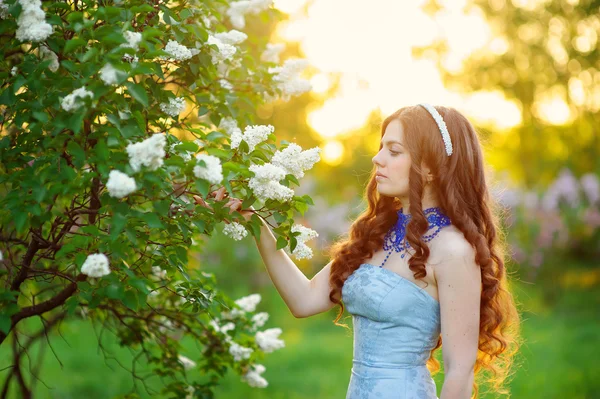 Krásná žena v jarní zahradě Lila — Stock fotografie