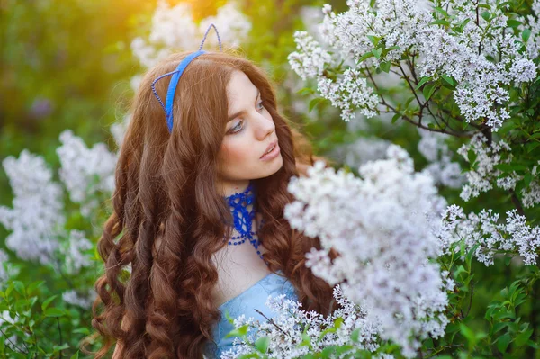 Bela mulher no jardim de primavera lilás na forma de um gato — Fotografia de Stock