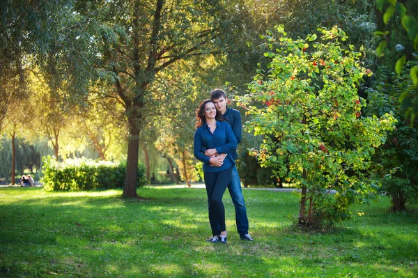 Jeune couple amoureux en plein air. Ils sourient et regardent ea — Photo