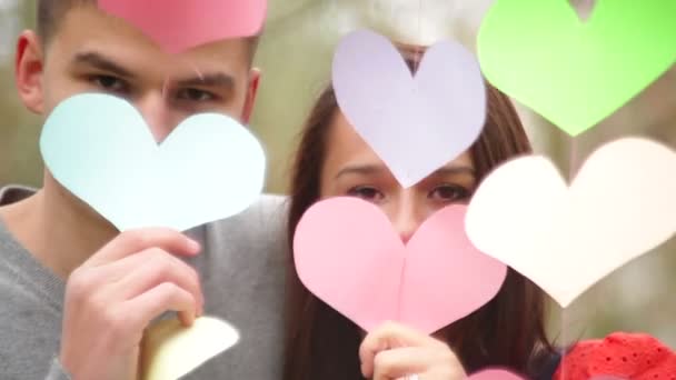 Loving couple standing near a multi-colored hearts — Stock Video