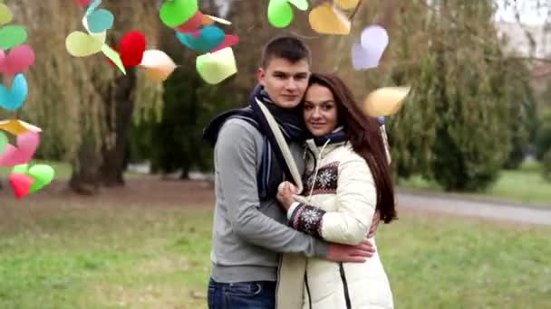 Любящая пара, стоящая рядом с разноцветными сердцами — стоковое видео