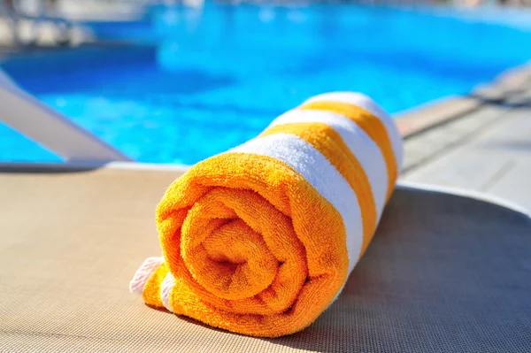 Bright beach towel on the background of the pool — Stock Photo, Image