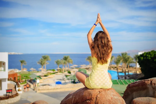 Woman is engaged in yoga on a background of the sea — Stock Photo, Image