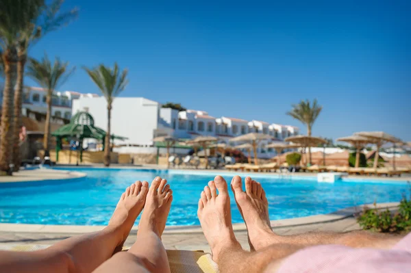 Feet resting on a background of the sea on the beach — Stock Photo, Image