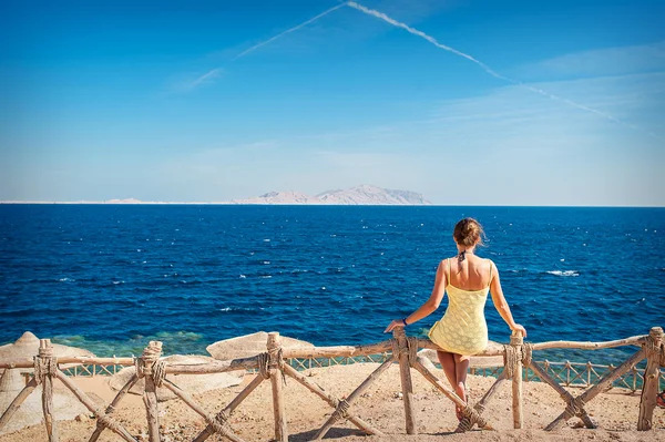 Woman sitting looking at the sea — Stock Photo, Image