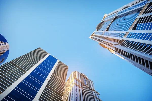 Bottom view of modern skyscrapers in business district in evenin — Stock Photo, Image