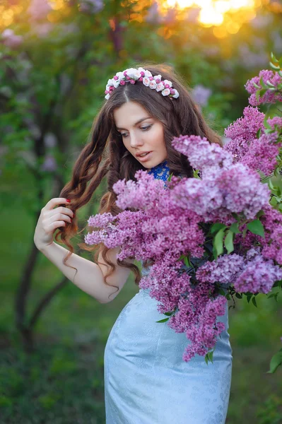 Menina bonita com flores lilás — Fotografia de Stock