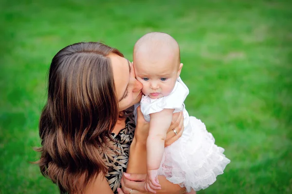 Jovem mãe beijando seu bebê filha — Fotografia de Stock