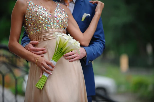 新郎在婚礼花束的白色马蹄莲百合拥抱女人 — 图库照片
