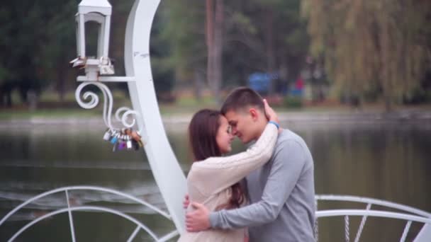 Αγαπώντας ζευγάρι στέκεται στο ΚΙΟΣΚΙ με τη μορφή της καρδιάς στο πάρκο — Αρχείο Βίντεο