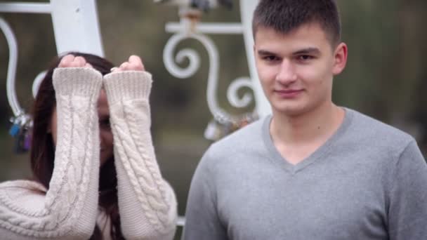 Любляча пара стоїть в альтанці у вигляді серця в парку — стокове відео