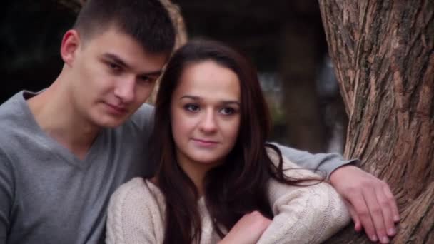 Milující pár stojící všeobjímající poblíž stromu v parku — Stock video