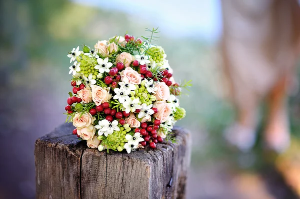 Hermoso ramo de bodas con flores rojas tumbadas en un tronco de árbol —  Fotos de Stock