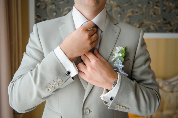 Man in a suit straightens his tie with cufflinks on their sleeve — Stock Photo, Image